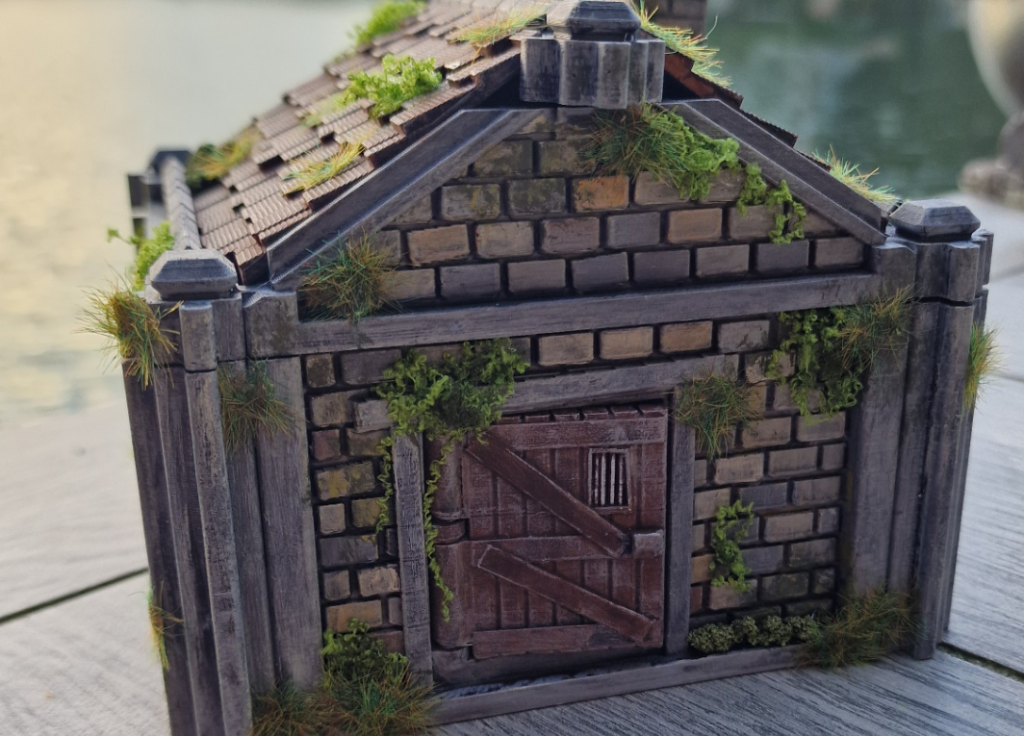 Miniature Brick Shed with Ivy and Moss Growing on the Walls and Roof a Weathered Wooden Door in the Center